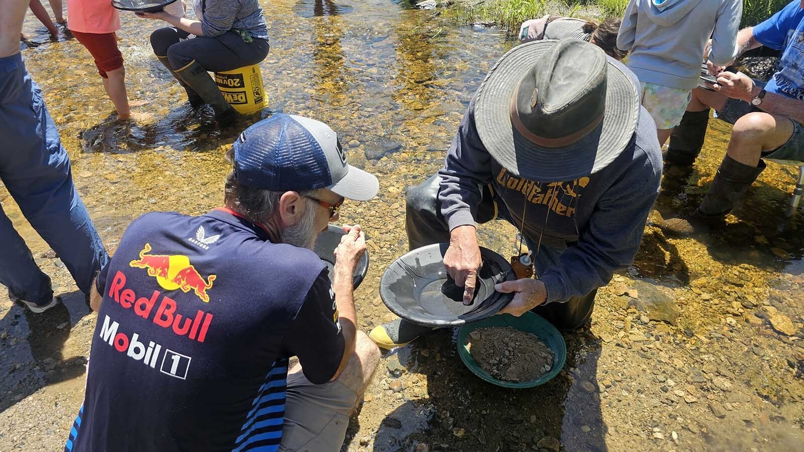 Larry Rohde demonstrates picking up a gold flake using a dry fingertip. It will be placed on a vial full of water, to capture the gold.