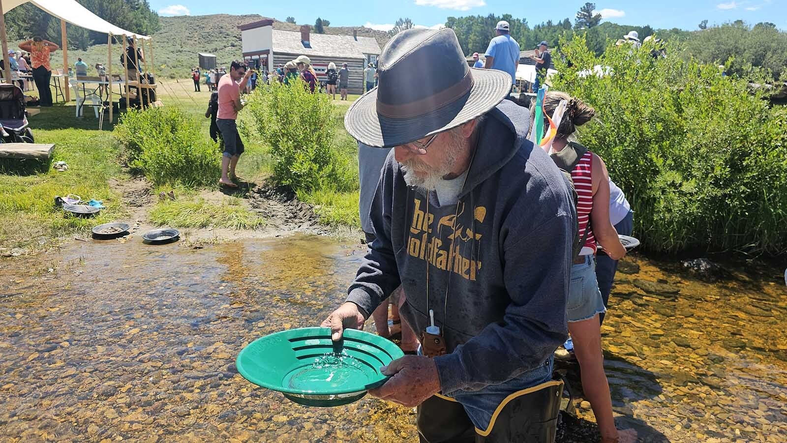 Larry Rohde looks for gold flakes during Gold Rush Days at South Pass City. He was one of several Wyoming Prospector Association members at the event, helping newcomers learn to pan for gold.