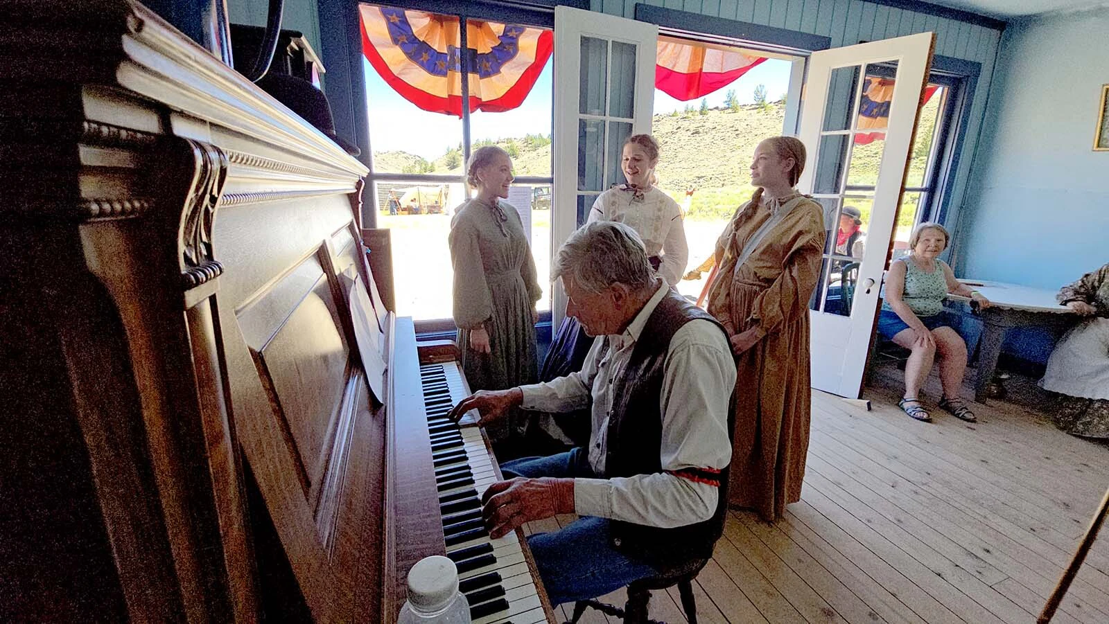 South Pass City's piano man John Mionczynski plays 1800s tunes while members of the North Platte Bridge Company sing along.