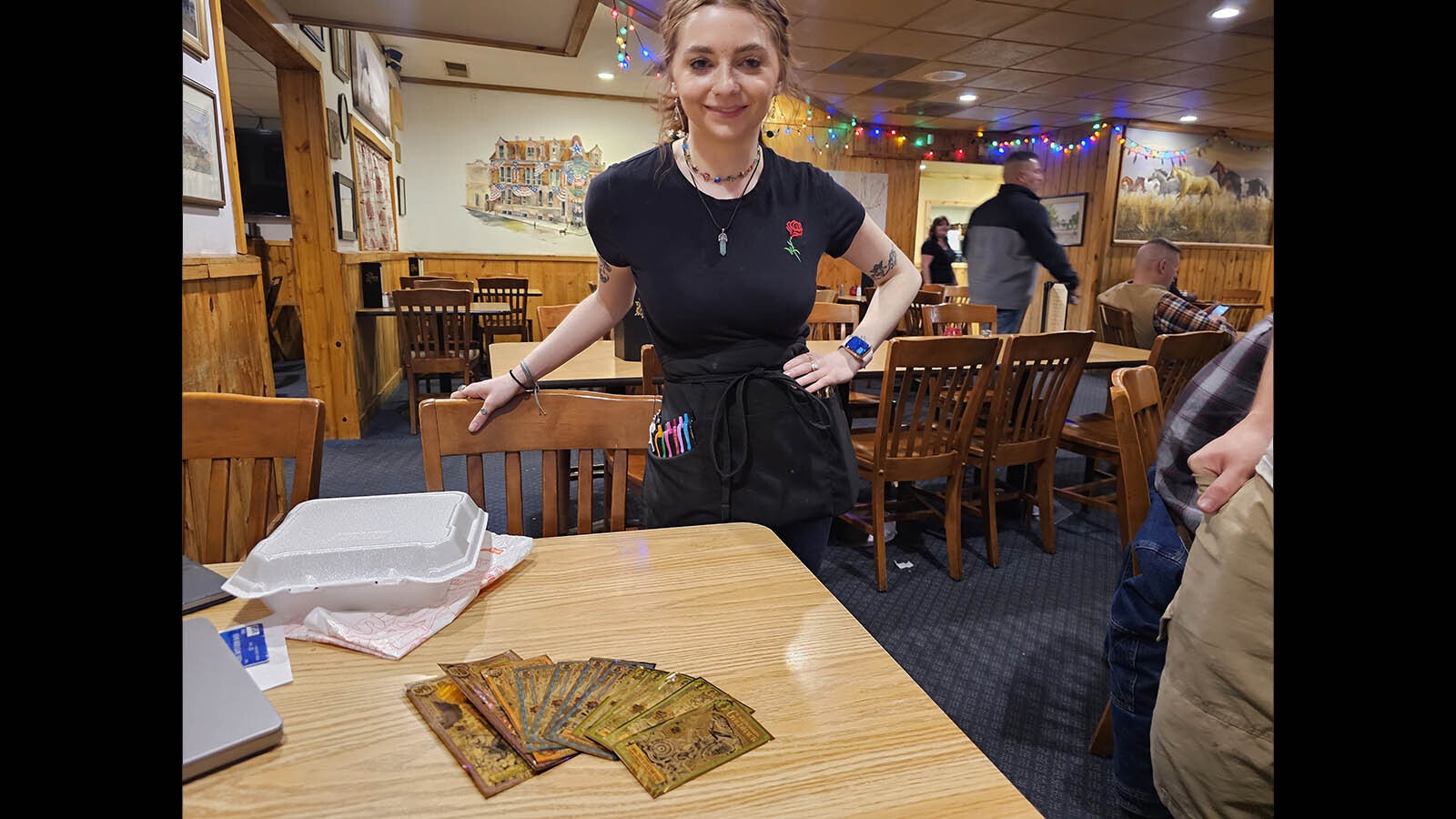 Jaquie Georgio, a waitress at T-Joe's Steakhouse and Saloon, looks at a collection of goldbacks from various states. She has yet to receive a tip in them, but said they are cool looking and she would love to get one.