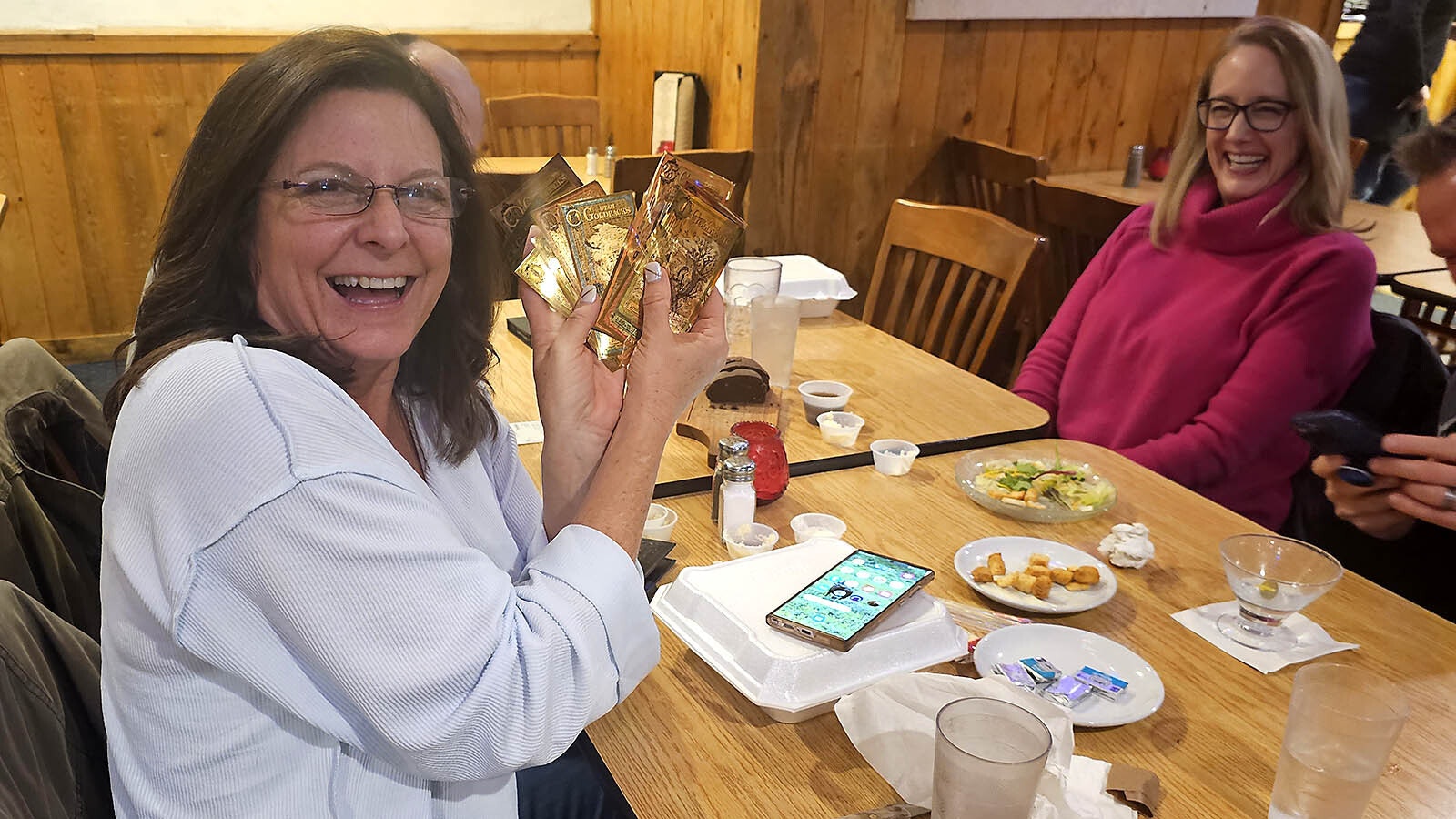 Laura Hoch holds up goldback bills she and her husband Chris intend to use to pay for their dinner at T-Joe's Steakhouse and Saloon in Cheyenne. The couple drove up all the way from Fort Collins for dinner at a place where they can spend their goldbacks.
