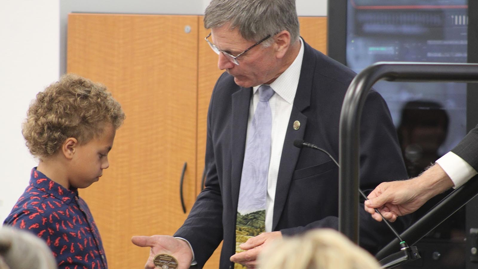 Gordon presents a Sheridan boy with a Wyoming State Challenge Coin after he led the Pledge of Allegiance.