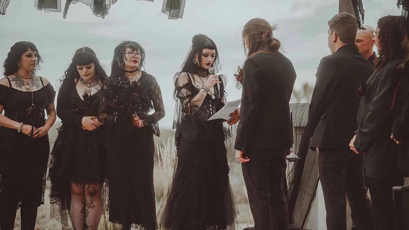 Renee Rotting reads her vows to Shawn Hill beneath strips of black lace during their gothic wedding.