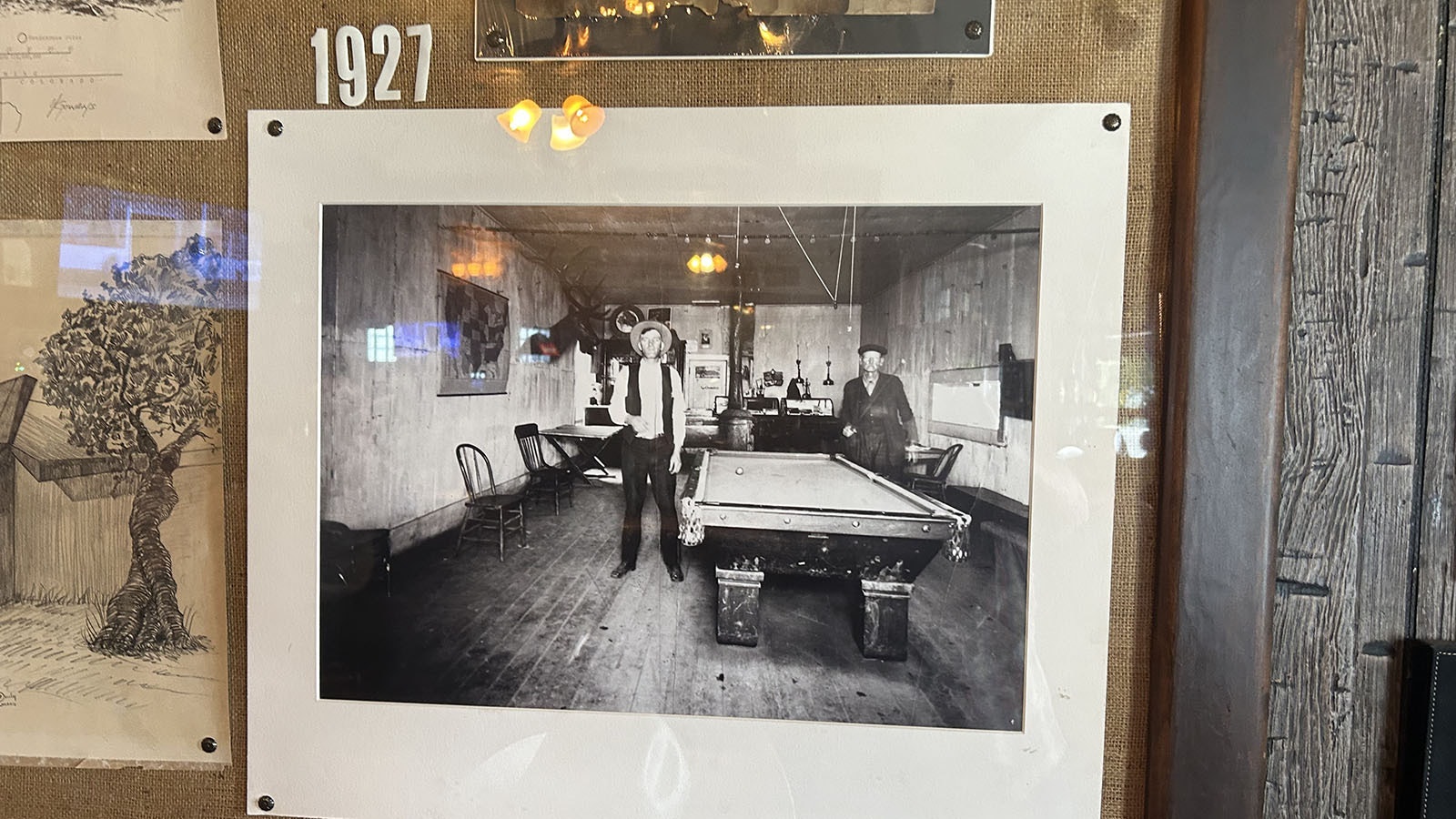patrons of the Green River Bar shooting pool in 1927. Note the liquor cabinet in back left of the image. The same cabinet is still in the bar.