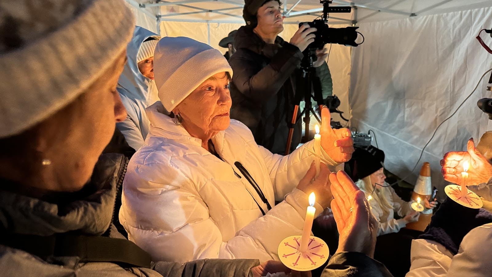 Sheila Franklin, in white, lives in Oregon and is afraid to fly, but made her first airplane trip to attend a candlelight vigil for Grizzly 399 held Nov. 2, 2024. The world's most famous bear mean a lot to her and that, "I've cried every night since she died."