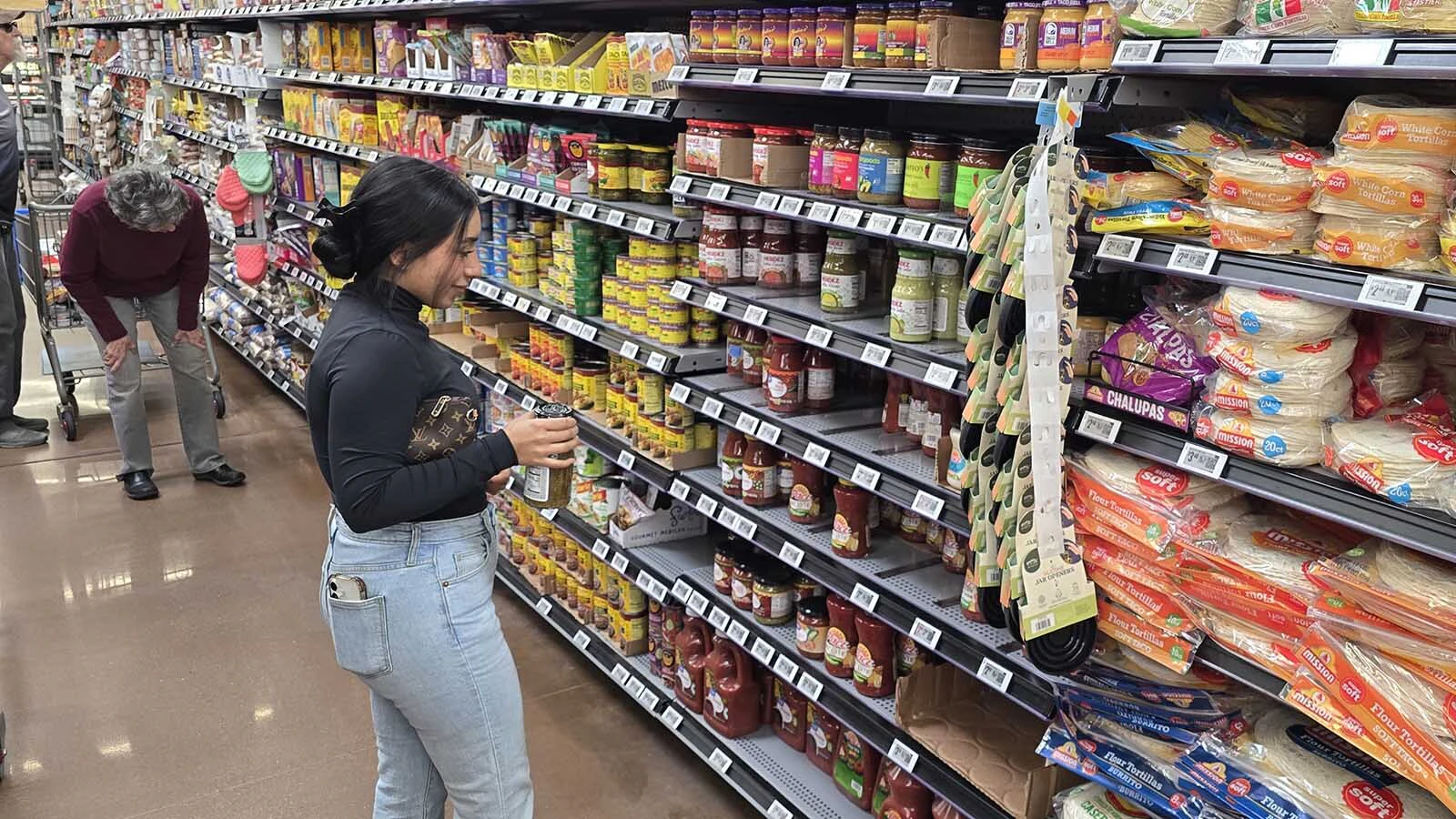 Lizbeth Gallegos looks for the right sauce to go into a recipe while shopping in Cheyenne Walmart on Sunday.