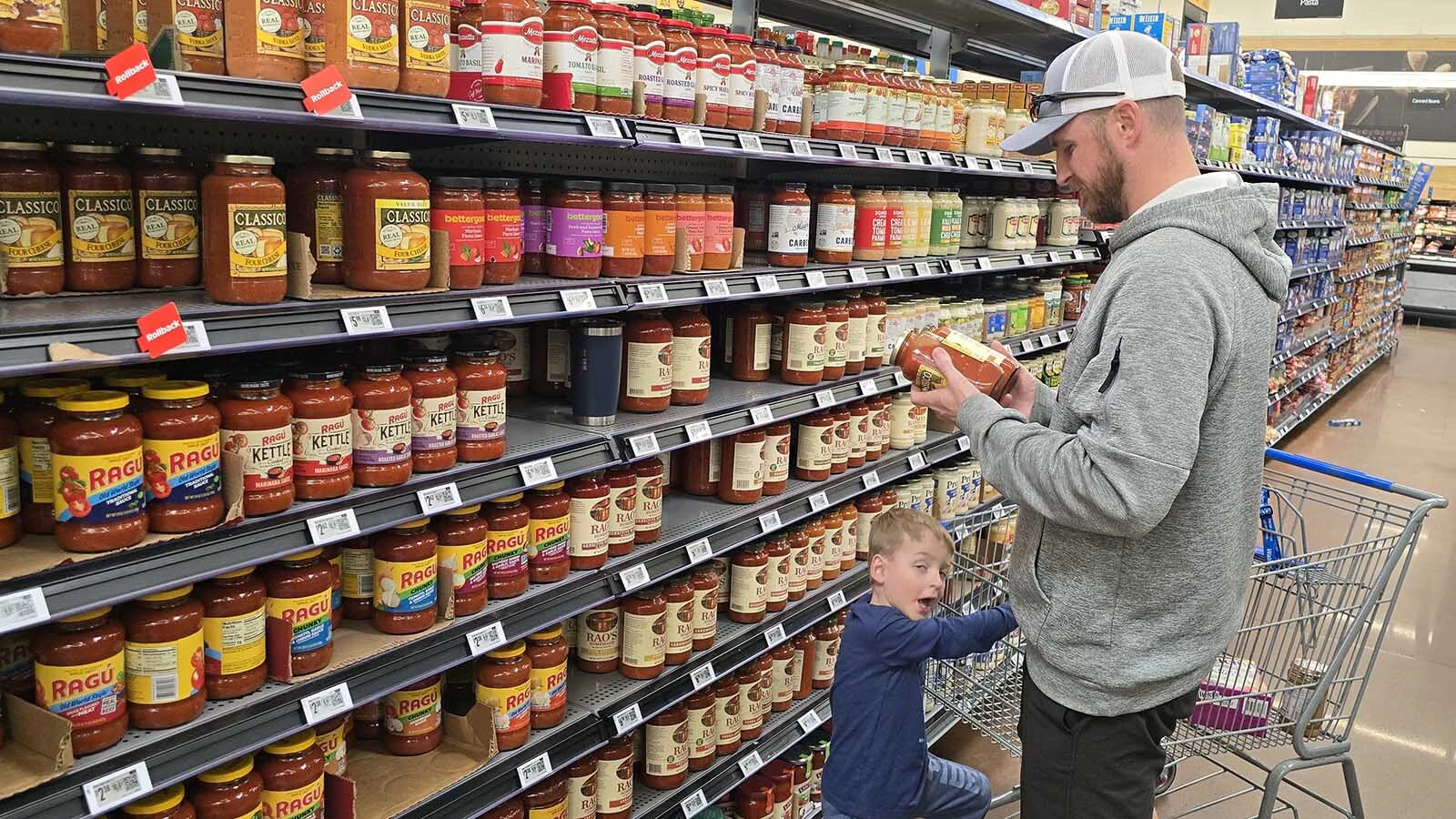 It's not always about the price. Here, Jake Wilson compares ingredients for spaghetti sauce, looking for the one with the least added sugar, while his son, Gavin, looks on. The one with less sugar also turned out to be the cheapest jar. Win-win for him.