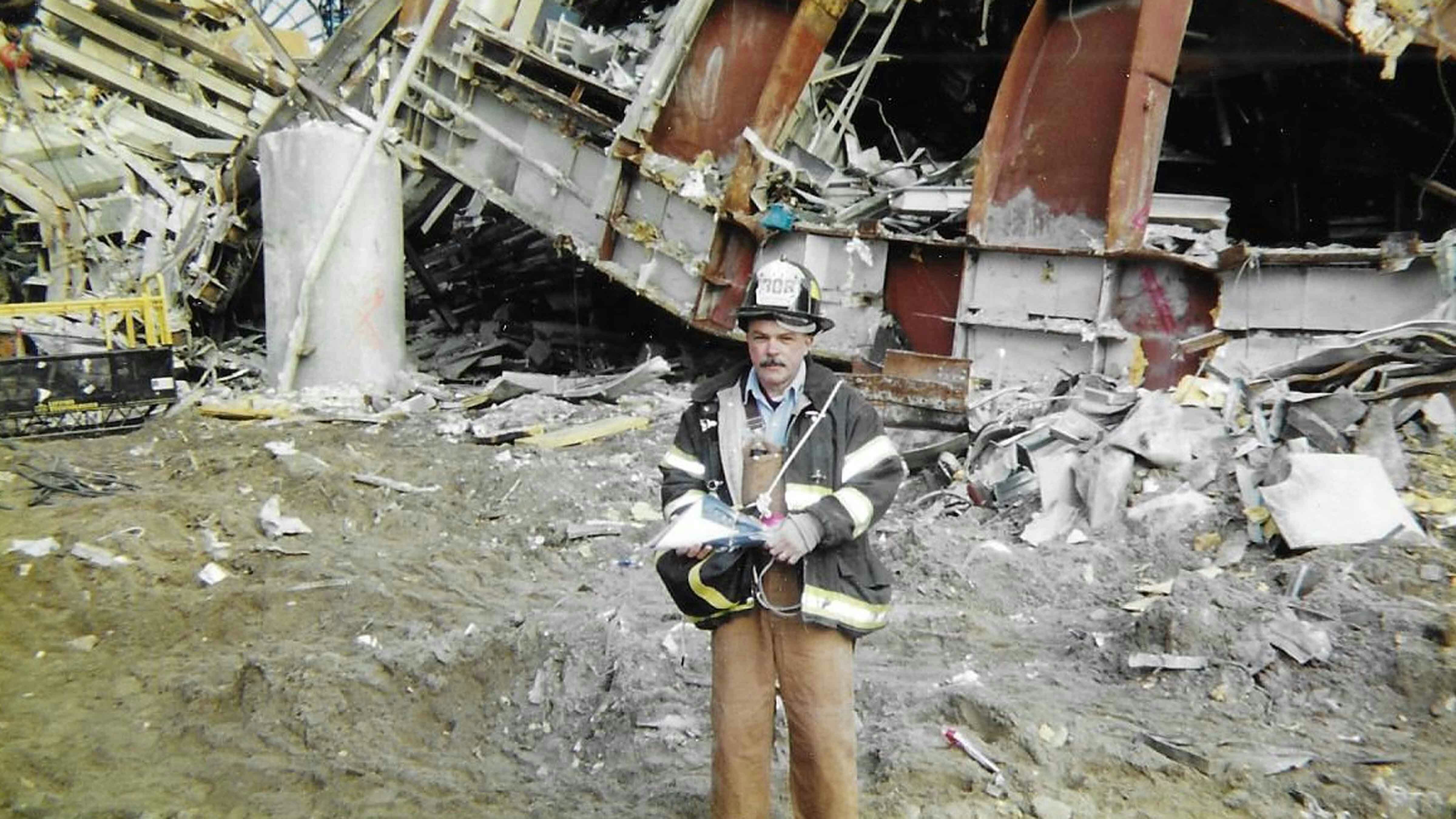 Bill Groneman with Lone Star flag in front of wreckage of West Street pedestrian bridge, Sept. 25, 2001