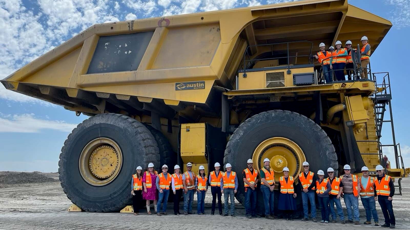 U.S. Rep. Pete Stauber, R-Minnesota, and U.S. Rep. Harriet Hageman, R-Wyoming, stand in the middle of Wyoming coal workers at the base of a haul truck at the rim of the Belle Ayr coal mine owned by Eagle Specialty Materials near Gillette. The lawmakers, who were joined by some staff members of the subcommittee on energy and mineral resources, met on Tuesday with miners and company representatives of Eagle Speciality Materials.