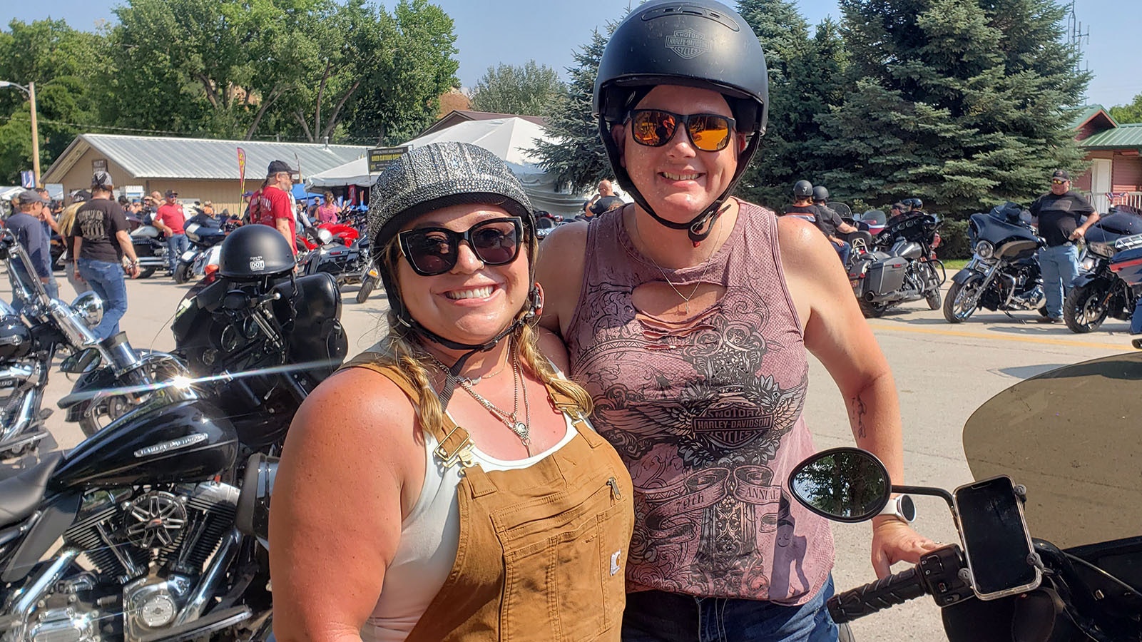 Kady Dubrock, left, with the sparkly helmet poses with Erika Green Labor for a photo. Dubrock is part of a younger generation that's been finding out about the Sturgis Motorcycle Rally.