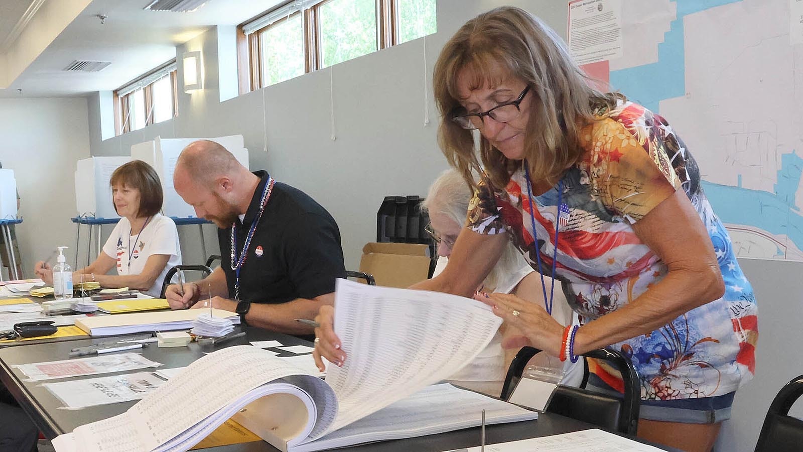 Evansville election judge Max Jacobsen looks through the voting roll midday on primary election day, Aug. 20, 2024.