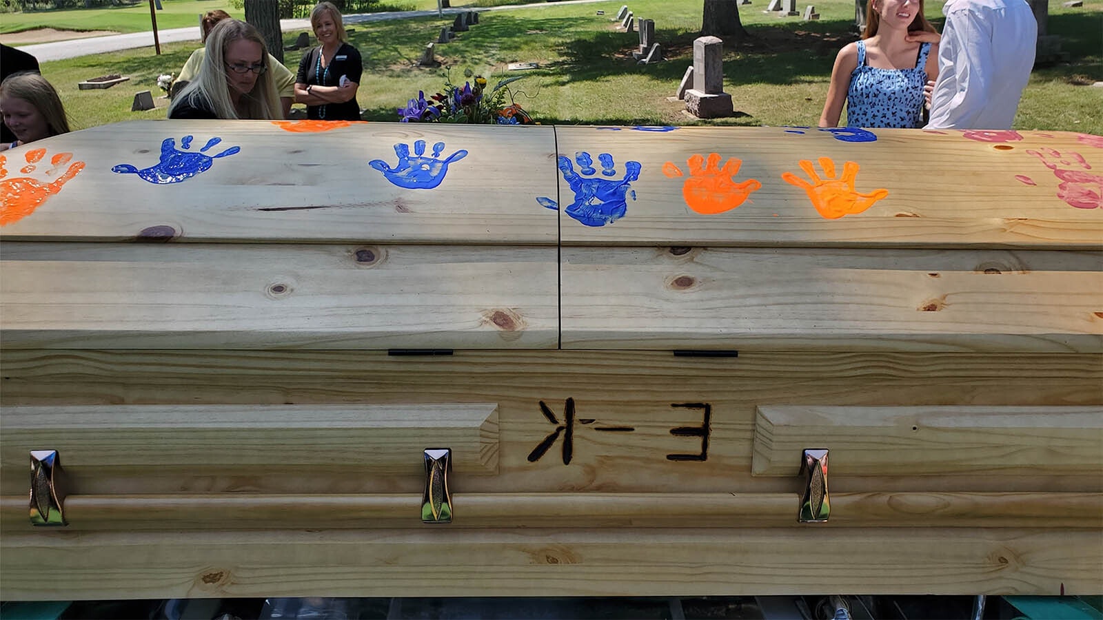 Along with burning cattle brands into caskets, other unique ways to remember loved ones include placing colorful handprints on them.