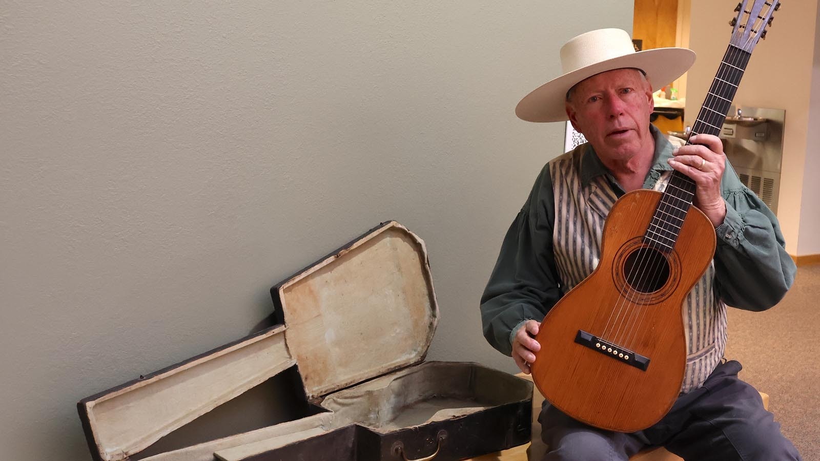 Hank Cramer poses with his 1870s parlor guitar and original “coffin” case. The guitar belonged to the inventor of the big-wheel bicycle or possibly his wife.