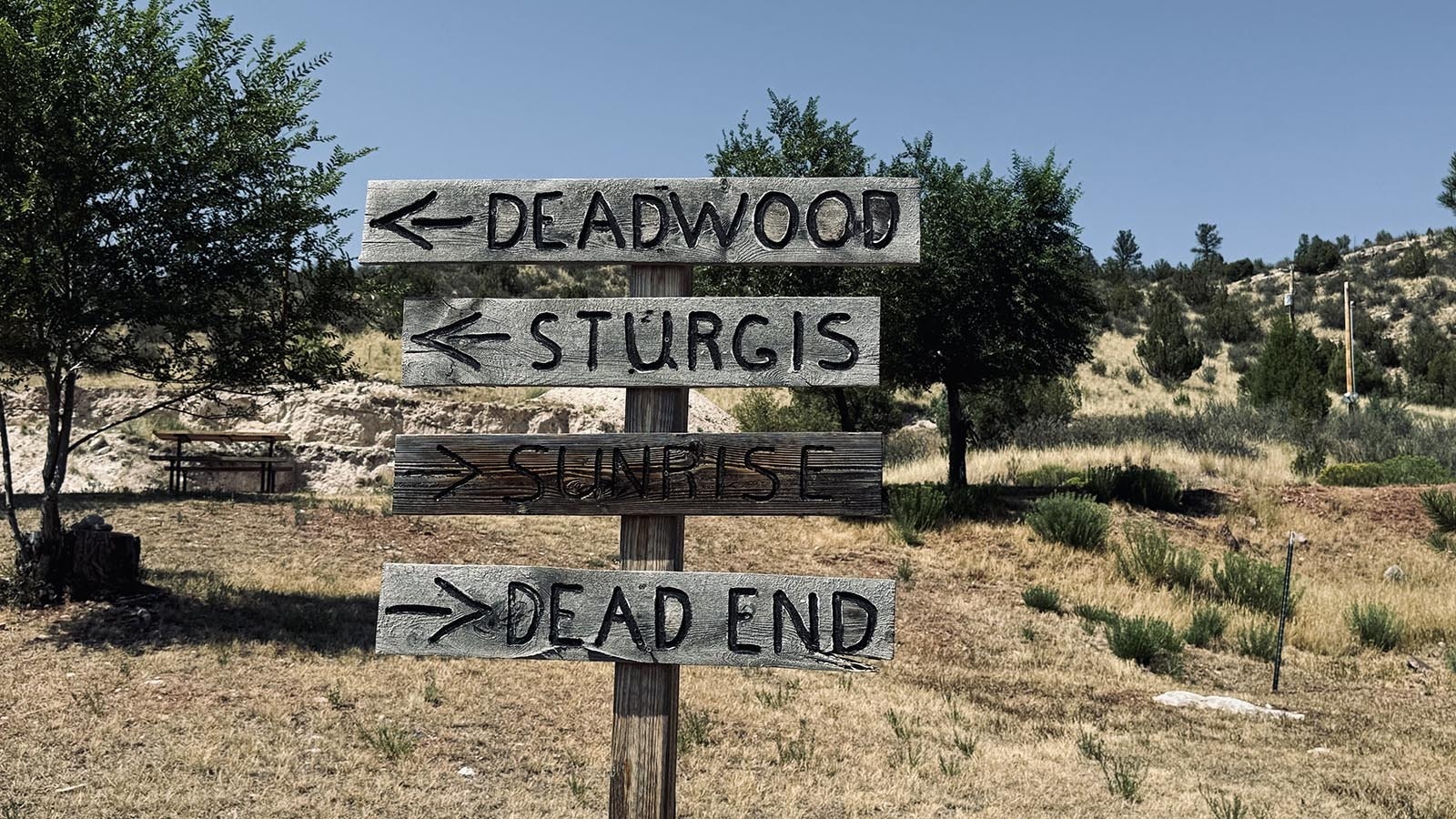 A sign at the entrance to Hartville points directions to Deadwood, S. Dakota, the Sturgis  motorcycle gathering in South Dakota, nearby mining town Sunrise, and the end of the road about a mile to the east of Hartville.