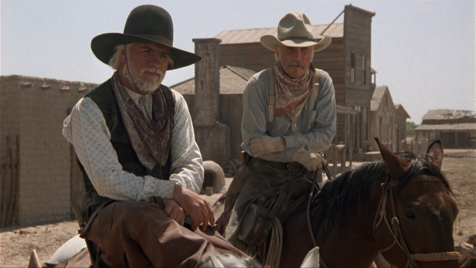 A scene from the TV Western "Lonesome Dove," at left, Tommy Lee Jones is seen wearing an unmodified Boss of the Plains or open-crease look. At right, Robert Duvall sports the peaked crown silver belly Montana look now known as the Gus.