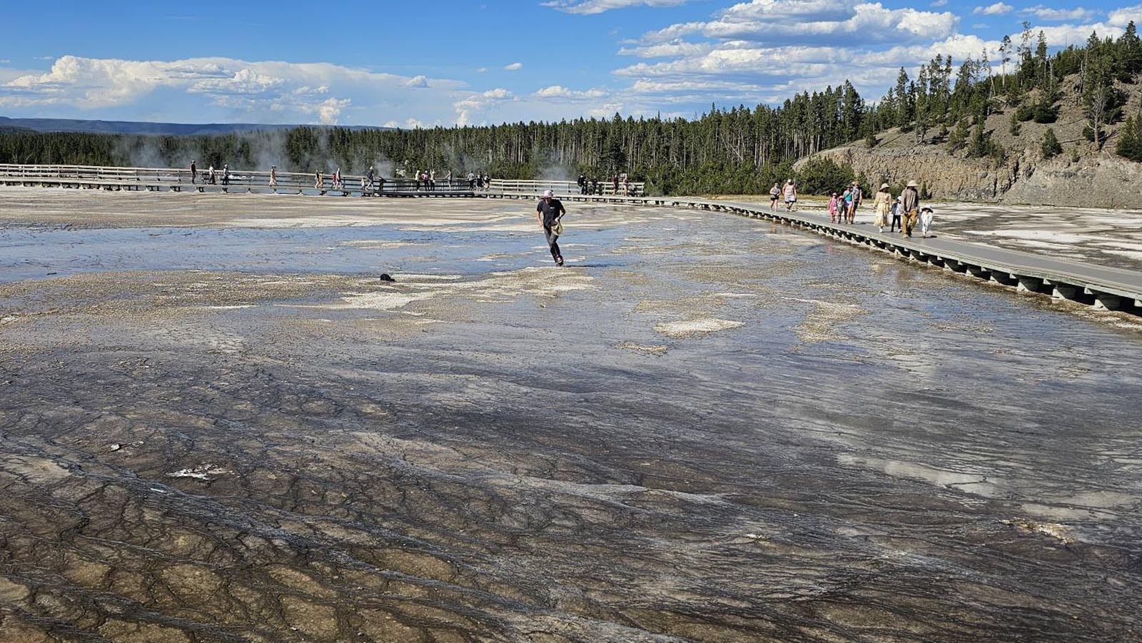 Other Yellowstone visitors were horrified Monday as they watched a man in flip-flops walking off the board walk onto the bacterial mats around Grand Prismatic Spring. He was picking up hats that had blown off people’s heads — and breaking the law.
