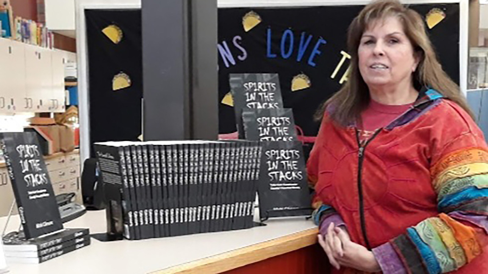 Micki Gilmore poses with her book “Spirits in the Stacks” when it was released in 2018.