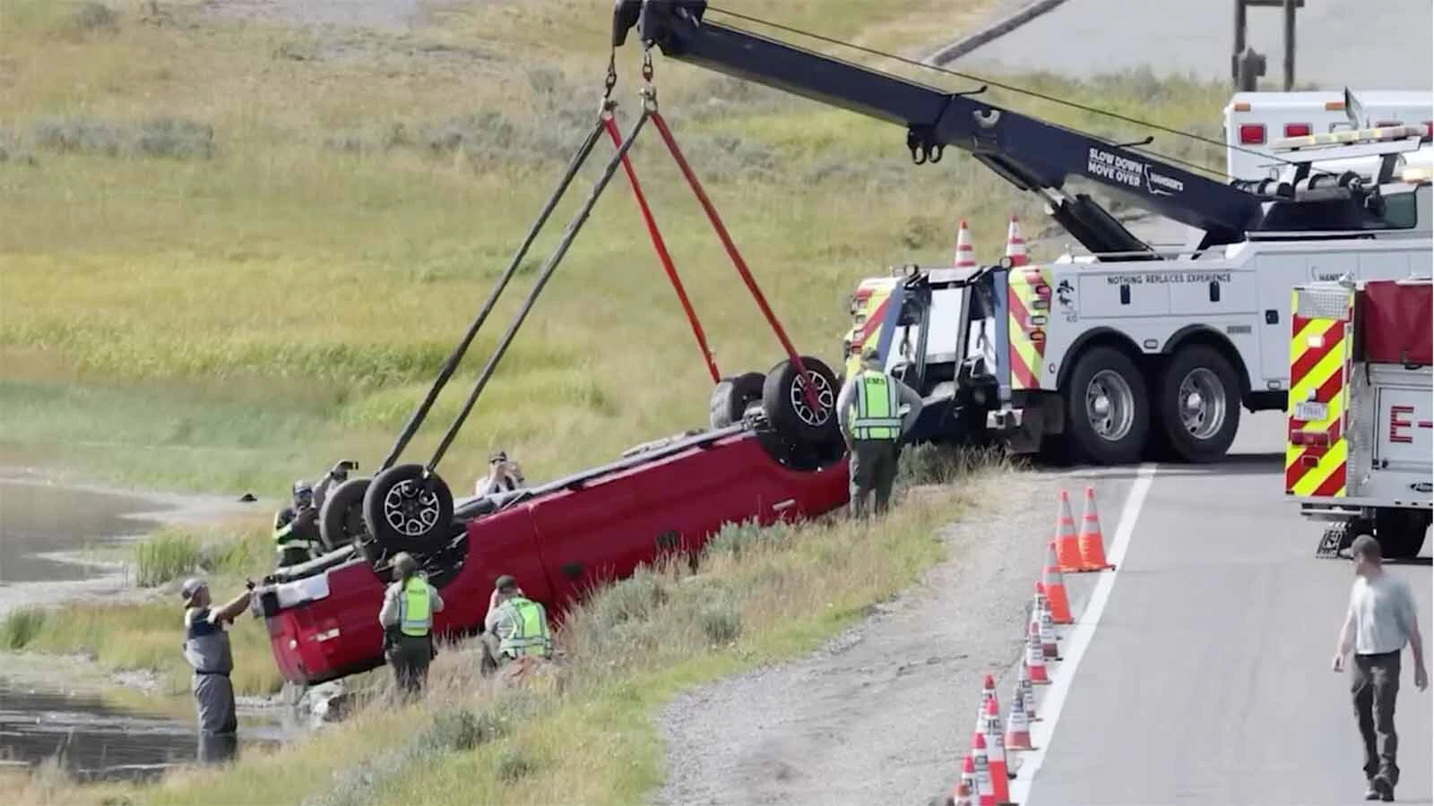 Crews work to pull an overturned truck out of the water along a roadway in Yellowstone's Hayden Valley.