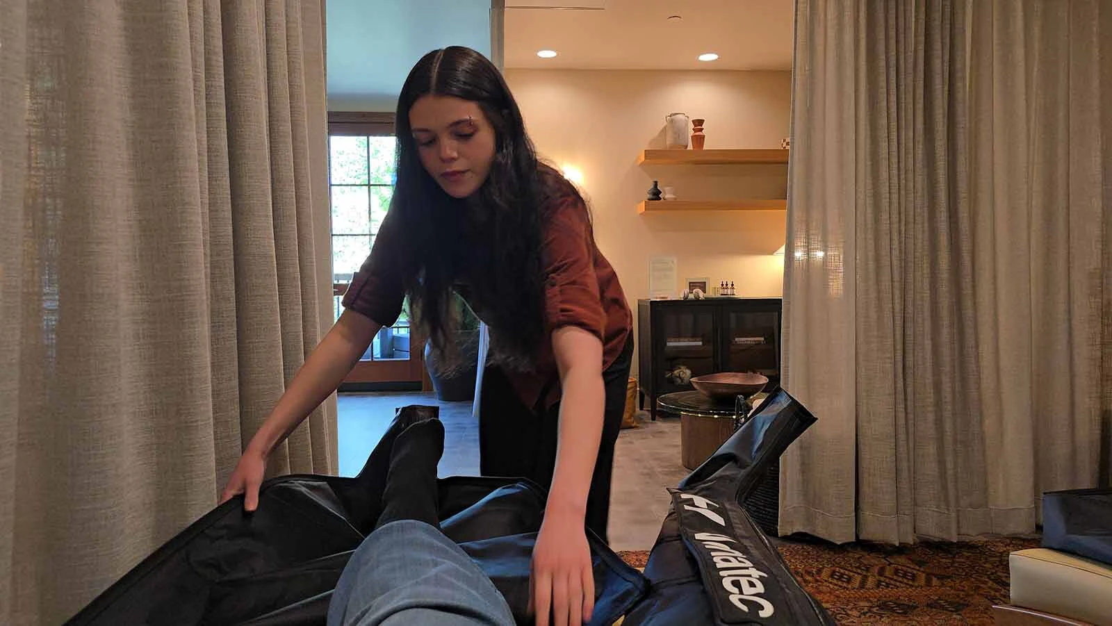 Andi Kerr adjusts compression boots for Cowboy State Daily at the Ember Lilly Spa, which is part of the former Snow King Resort in Jackson, now known as Trailborn.