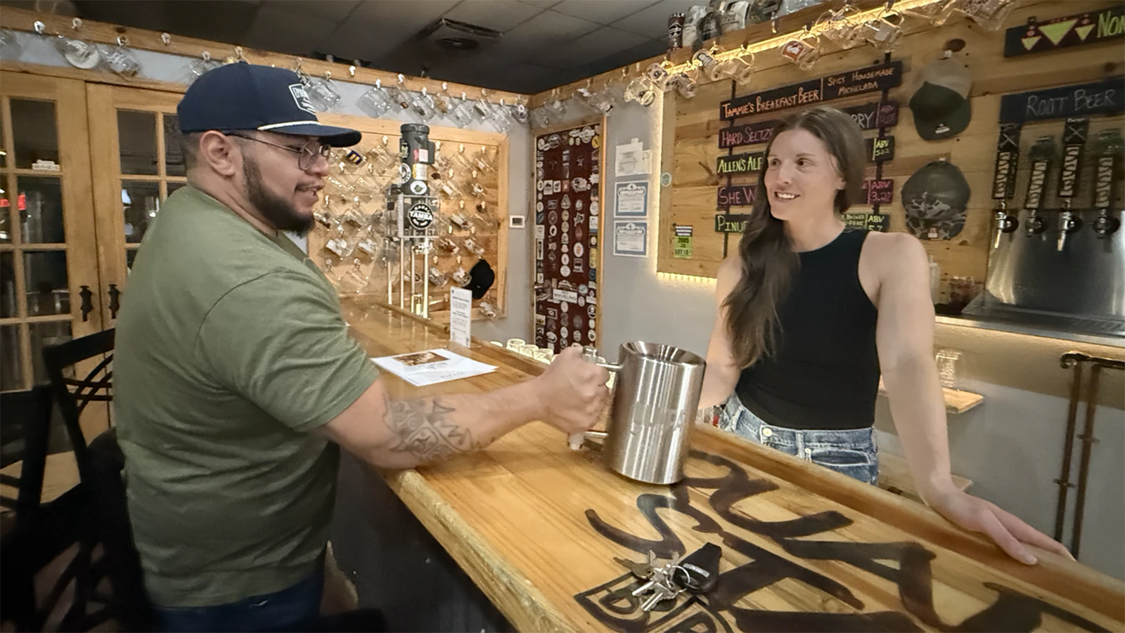 Cassandra Vincelette hands the mug to a patron preparing to attempt the heavy mug challenge at Square State Brewing.
