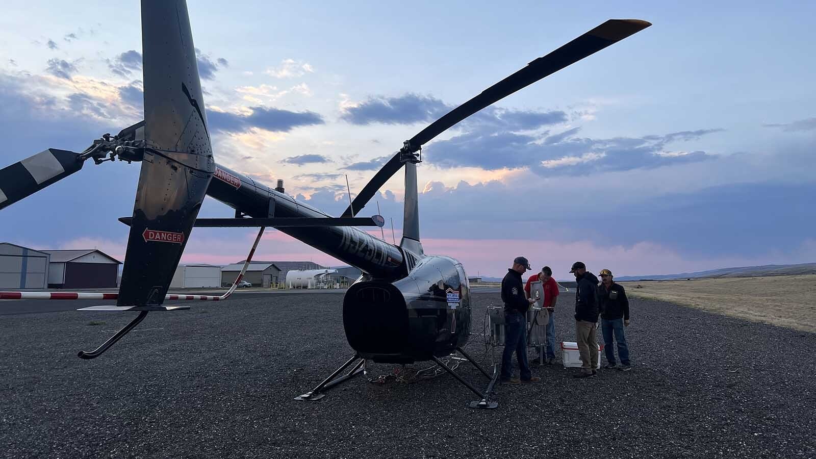 Wyoming Game and Fish personnel meet with a crew from Rugged Mountain Aviation commercial helicopter services early Tuesday at the Dubois Municipal Airport.
