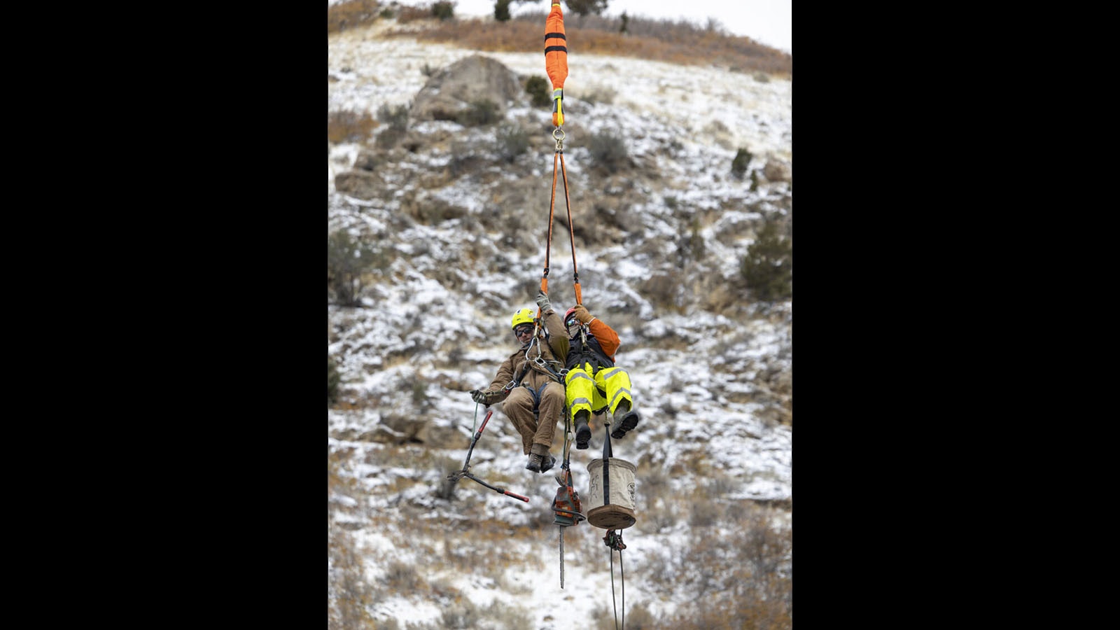 Electrical linemen students train to service power lines and equipment dangling from a helicopter.