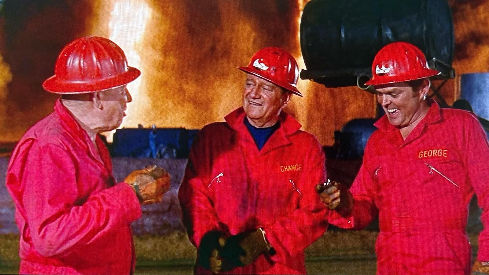 John Wayne, center, during a scene in the 1968 movie "Hellfighters" with oil rig fires burning in the background.