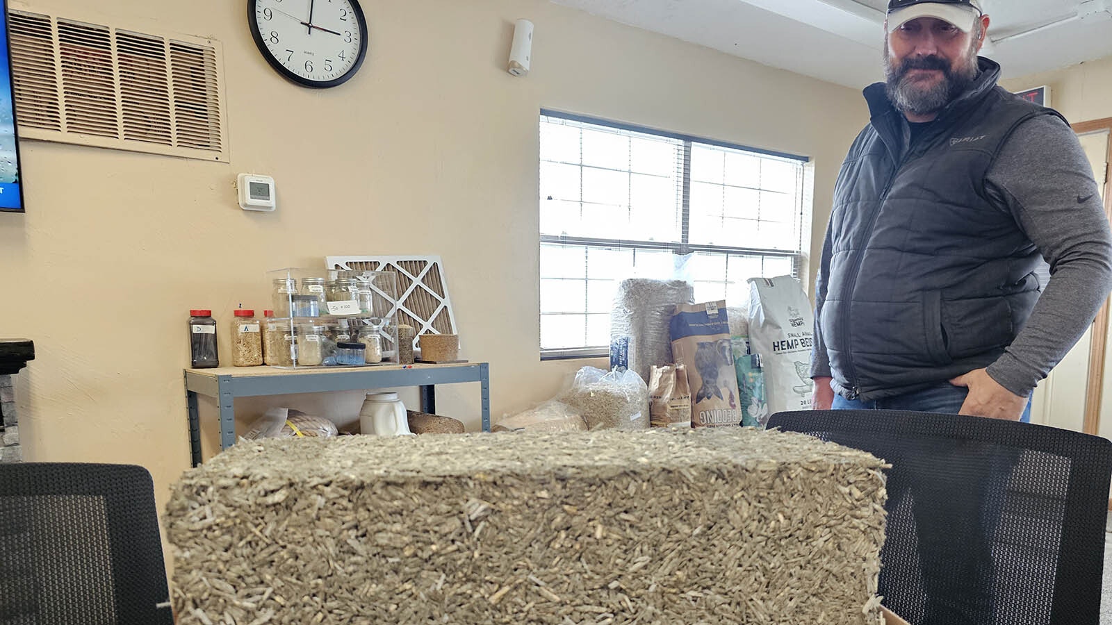 A block of hempcrete with Justin Loeffler behind. Hempcrete is extremely hard and is a concrete substitute made of hemp.