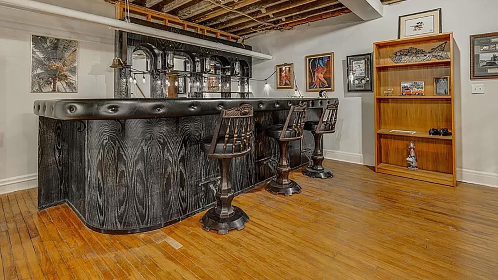 The original bar in the basement and three stools come with the home.