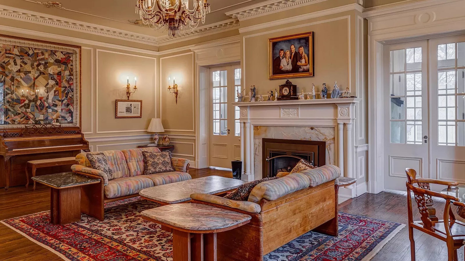 The living room is one of several rooms with a fireplace and offers exquisite ceiling molding and French doors leading to the “sleeping porch.”