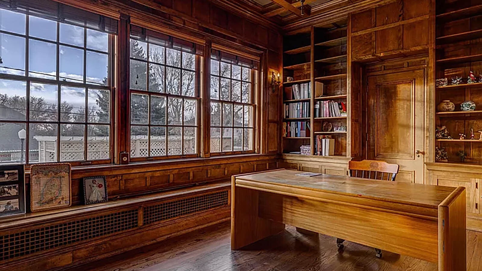 The office in the home features beautiful woodwork and built-in bookshelves.