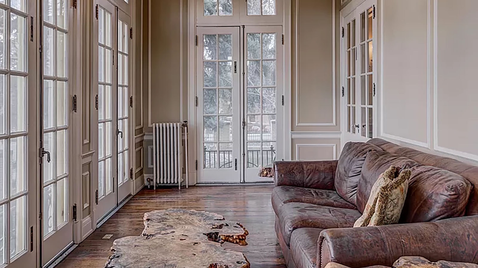 A “sleeping porch” off to the side of the living room and office offers French doors and original lamp fixtures.