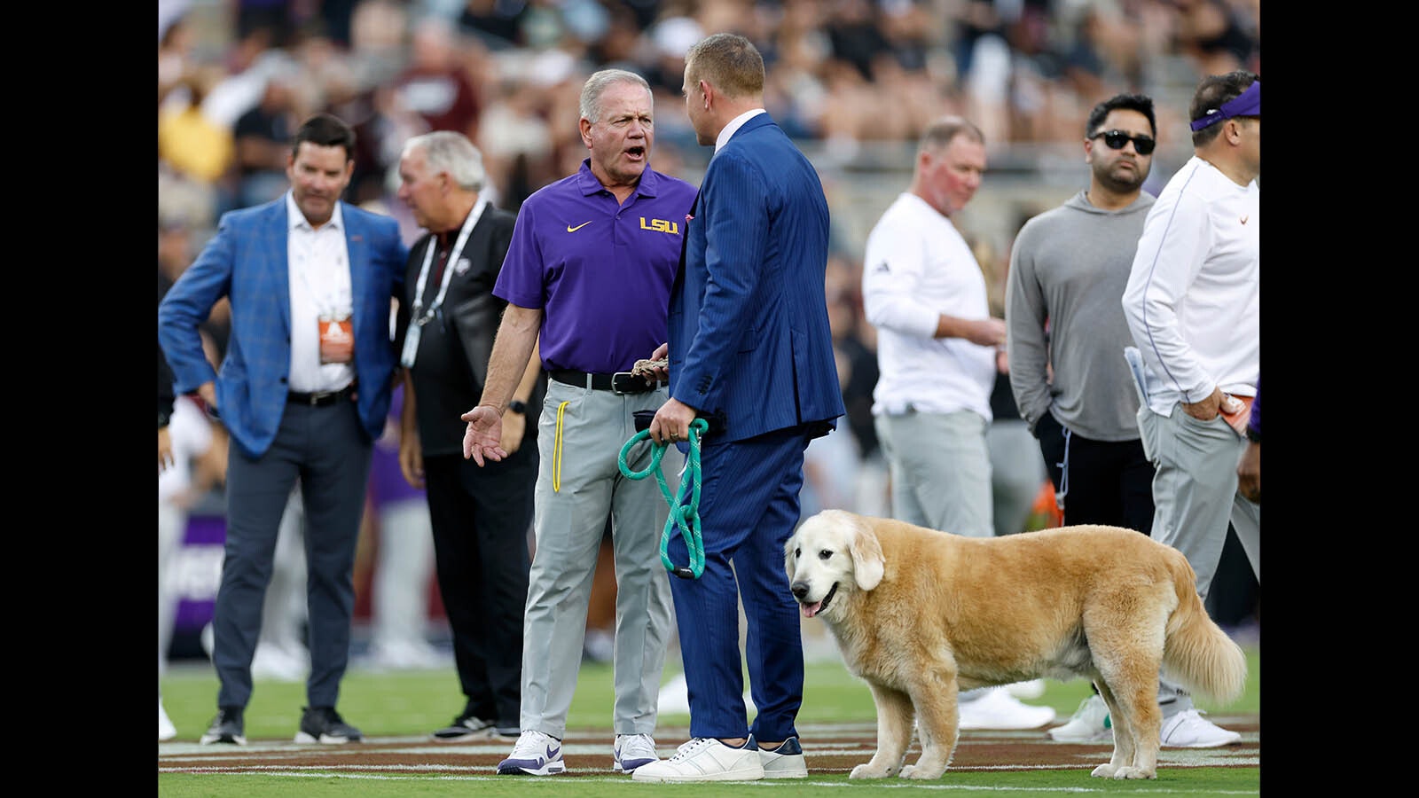 ESPN Analyst Kirk Herbstreit and his dog Ben speak with head coach Brian Kelly of the LSU Tigers before the game against the Texas A&M Aggies at Kyle Field on Oct. 26, 2024 in College Station, Texas.