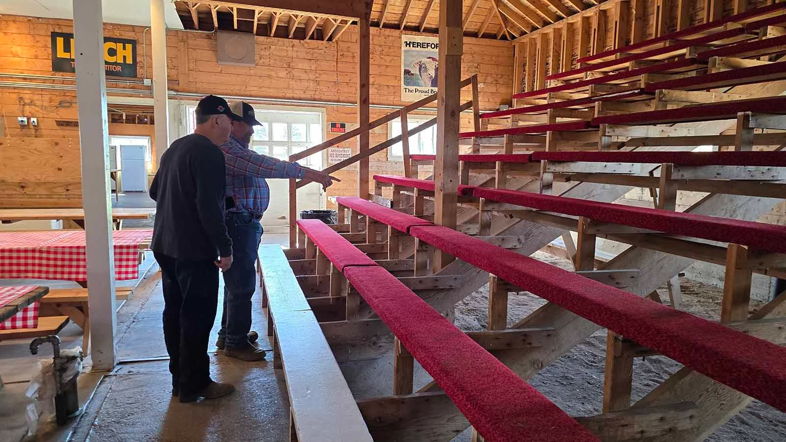 Gene Stillahn points to the spot where John Wayne used to sit when he came to the Wyoming Hereford Ranch sale barn not long after buying a ranch in Arizona.