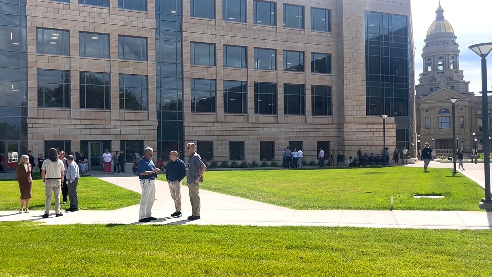 State of Wyoming employees mill around after the Herschler Building East was evacuated after receiving a threatening letter with a white powder Monday. A hazmat team responded to clear the threat.