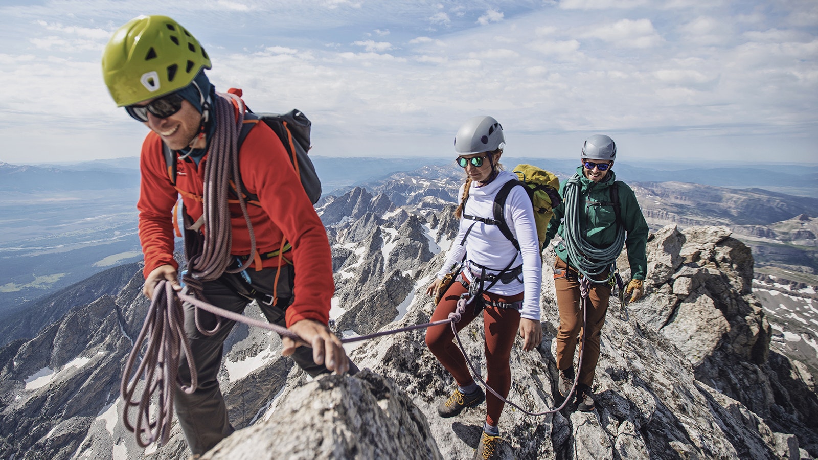 A group of hikers and climbers summit a peak in the Grand Tetons of Wyoming.