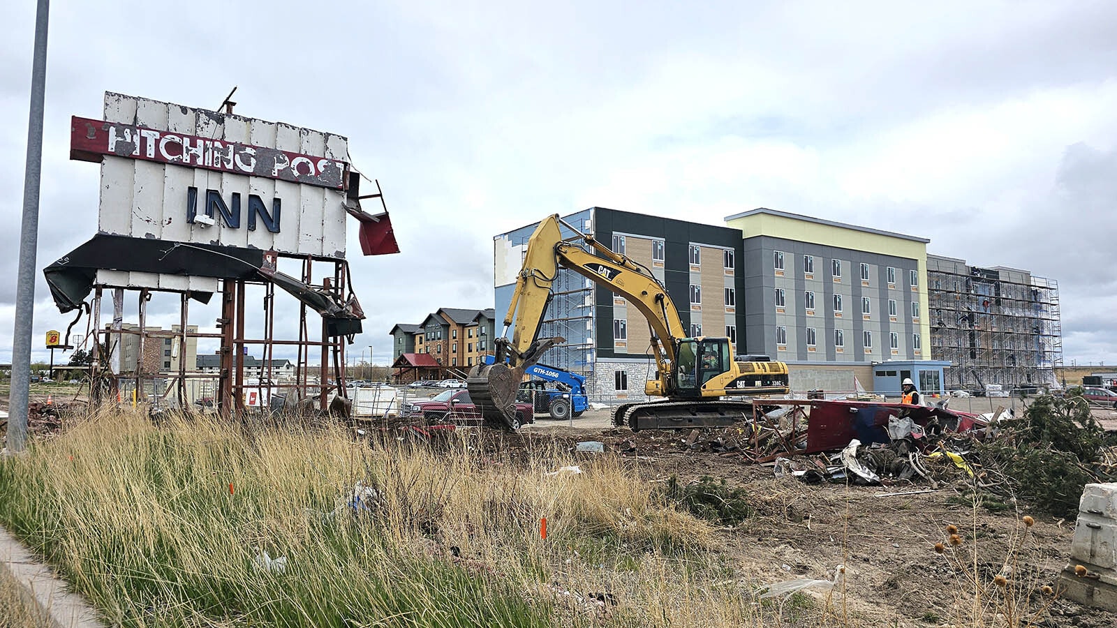 Workers dig out around the Hitching Post Inn sign to take it down Thursday, May 9, 2024. A worker on site was telling passersby that the sign is coming down for good. It will be sent to a museum, if it survives the process.