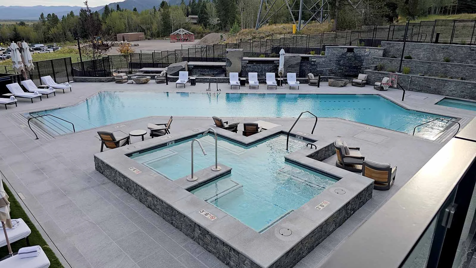 A set of hot tubs look out over the infinity pool at Hoback Club.