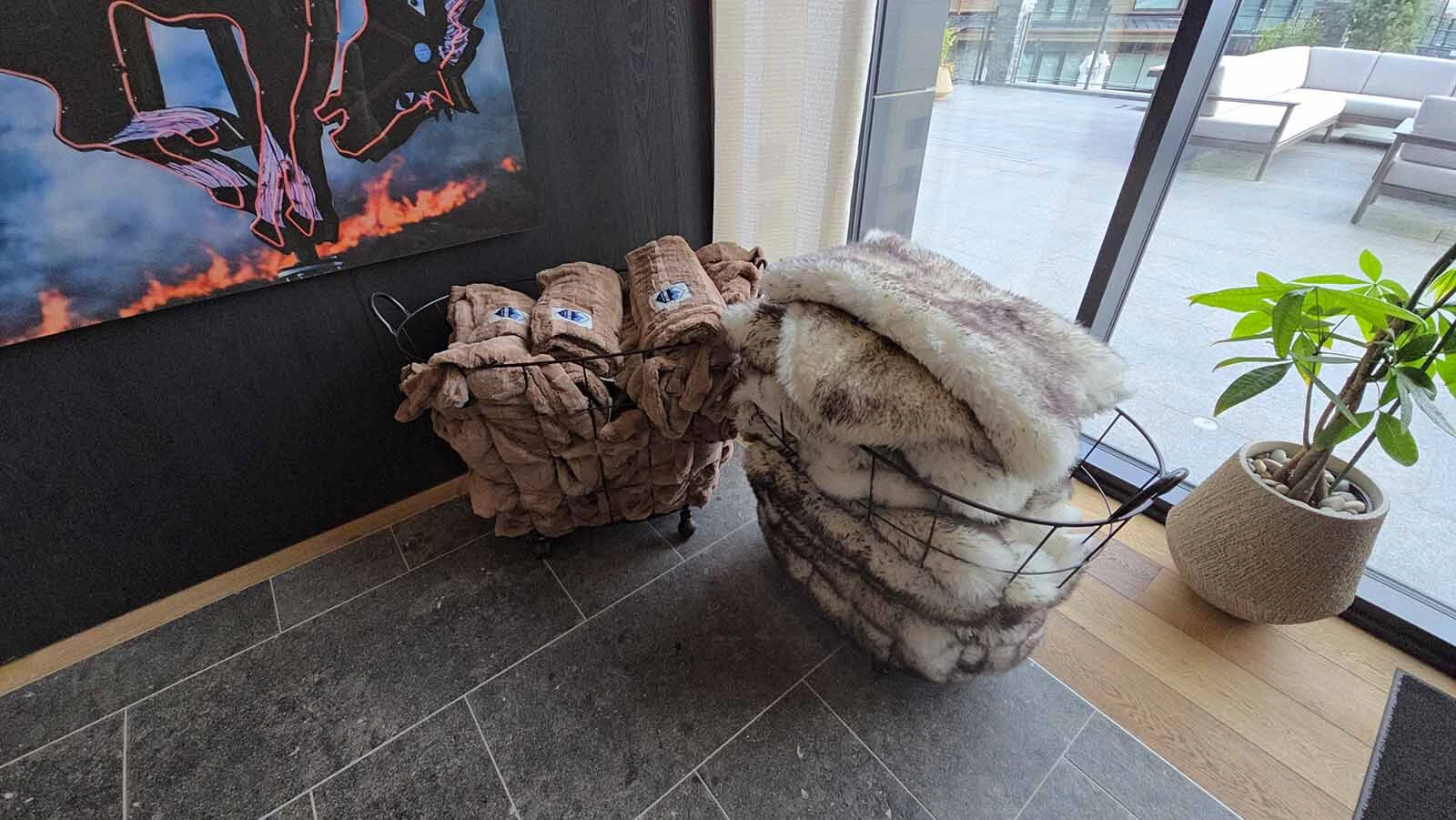 Baskets of sheepskin throws and velvet-soft blankets for use in the outdoor pool area.