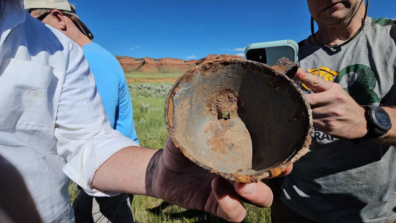 Closeup of a tin cup with a single bullet hole shot through it. Clay Gibbons believes it might be evidence of a historical crime in the Hole in the Wall country.