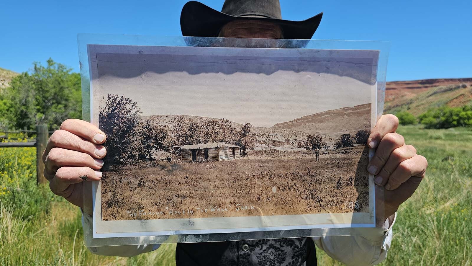 Clay Gibbons holds up a photo, then invites participants of his 2024 tour to take a look at the photo and then at the scenery, and see if they aren't standing right where the photographer who took that photo stood.