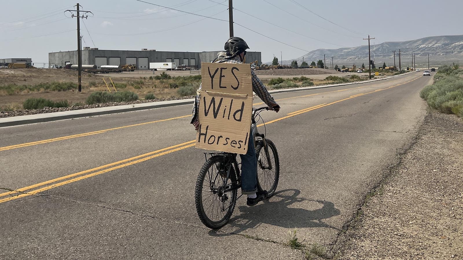 A supporter of wild horses in Wyoming rides along a highway near Rock Springs.