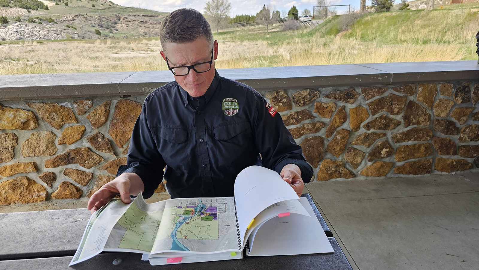 Wyoming State Parks Big Horn District Manager Brooks Jordan pages through the state's 2016 Master Plan for Hot Springs State Park to answer a few questions for Cowboy State Daily.
