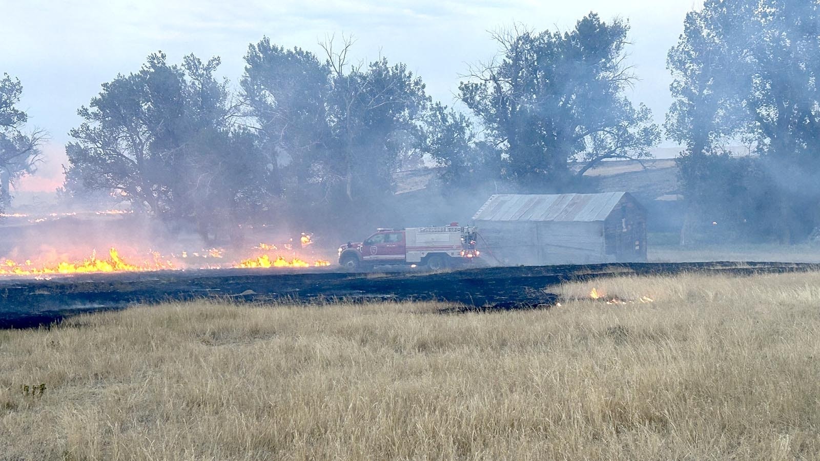 A firetruck tends to an active fire line on a Johnson County ranch during the House Draw Fire in this file photo. The House Draw fire was started Aug. 21, the same day as a much smaller, 30-acre fire that began in a burn barrel.