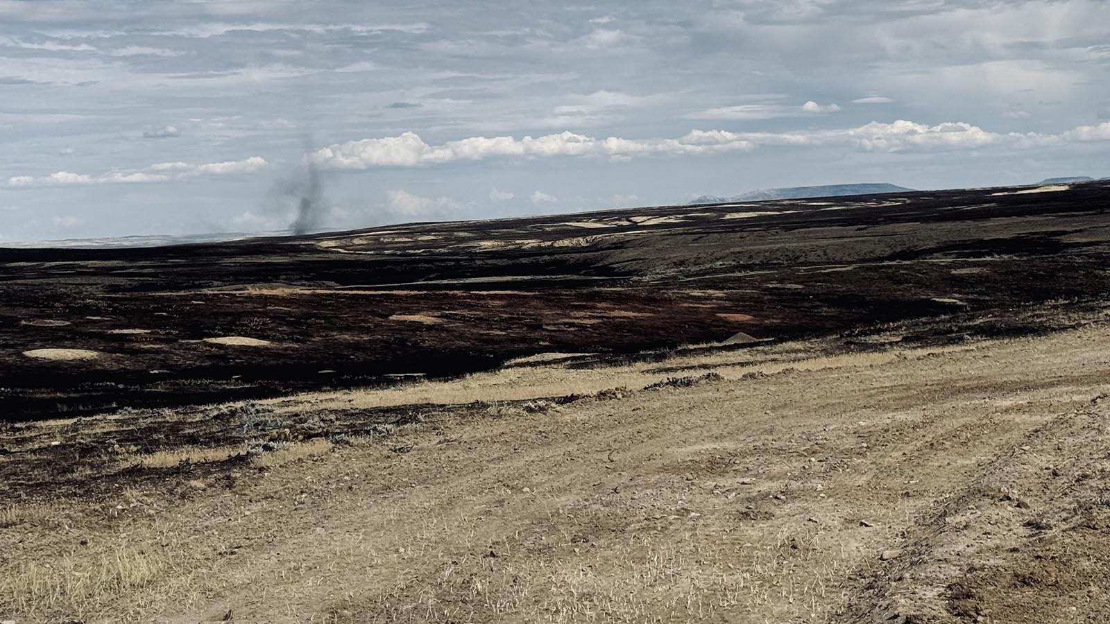 Above, a smoldering fire can be seen on the prairie off Buffalo Sussex Cutoff Road.