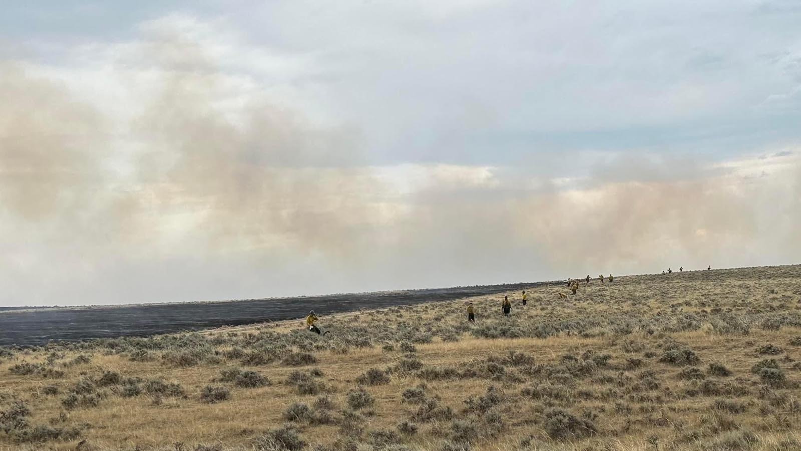 Smoke drifting across the plains where sheep from local ranches graze.