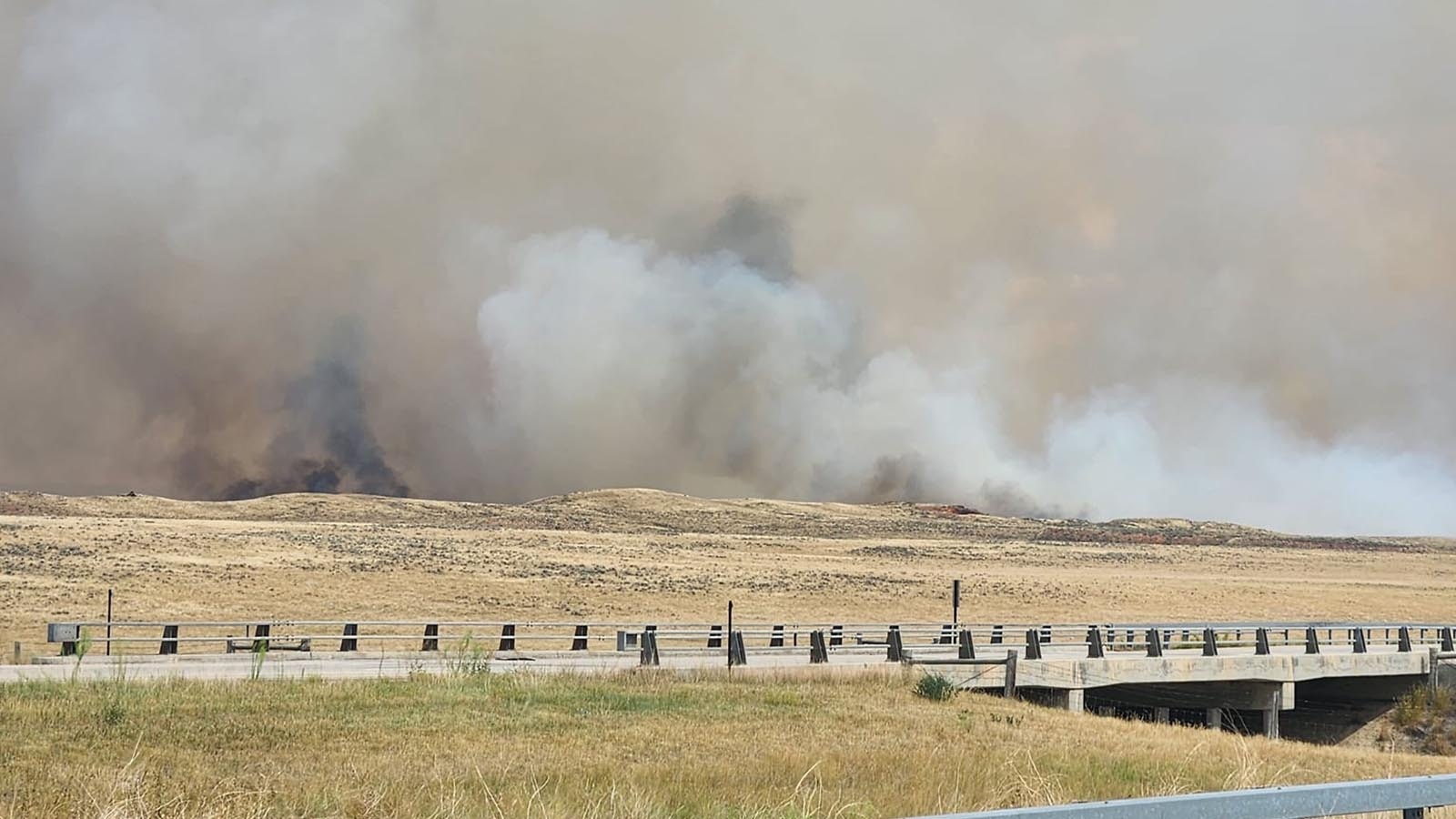 A wall of smoke rises from the edge of the House Draw Fire in this image shared by Triple Three Outfitters.