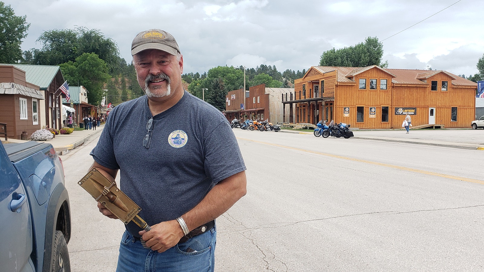 Tom Coronato with a door pull he found in the UK for his new building on Hulett's Main Street, in the background. It's the first new building on Hulett's Main Street in 40 years.