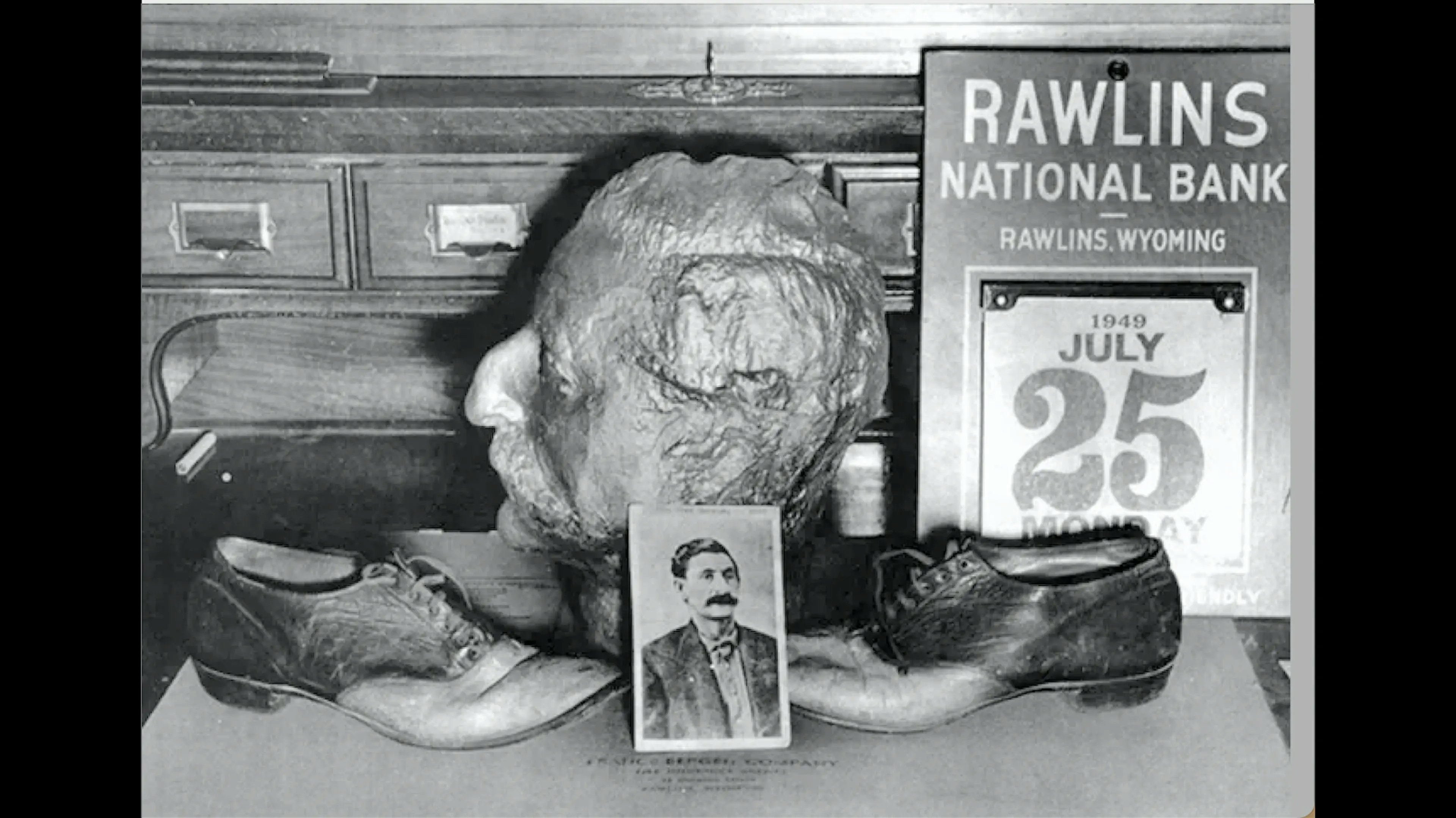 The death mask of "Big Nose" George Parrott, along with a pair of shoes made from his skin and other artifacts, on display in the Rawlins Bank in 1949.