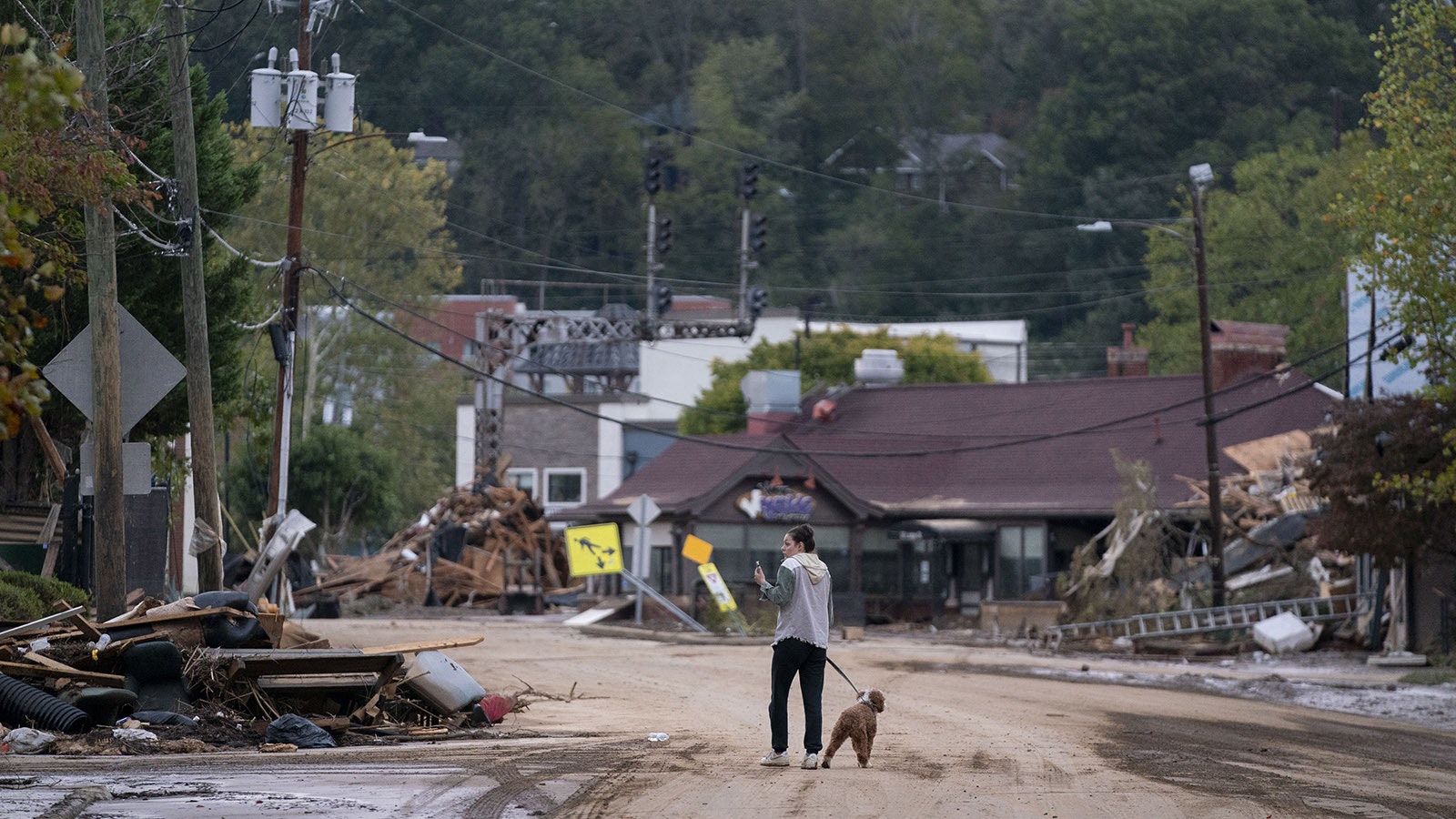 Mary Grace and her dog, Marley, walk around the Biltmore Village in the aftermath of Hurricane Helene in Asheville, North Carolina. According to reports, more than 60 people have been killed across the South due to the storm, and millions have been left without power. North Carolina has been approved for a Federal Major Disaster Declaration.